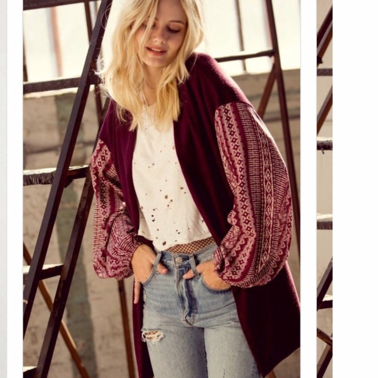 Brushed knit cardigan featuring an open front draped silhouette, dropped shoulders, and a super cute woven puff sleeve in berry color